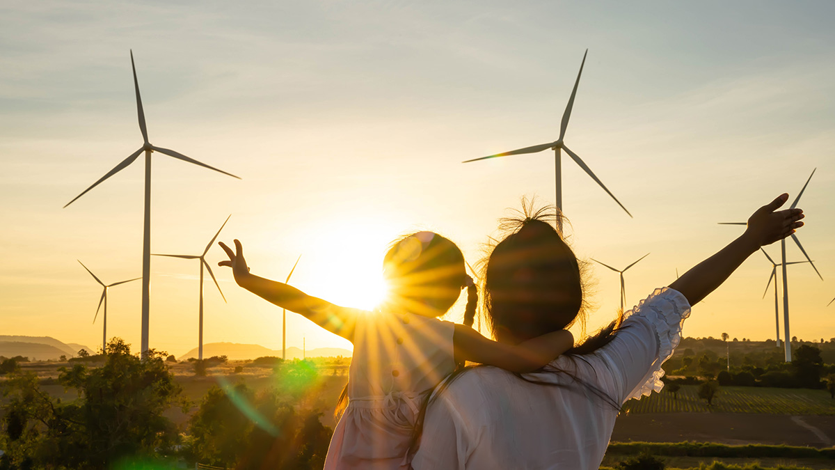 Family at sunset in front of wind turbines image