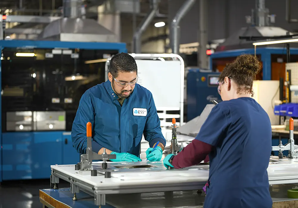 Two ESS employees working on the factory floor to build LDES batteries