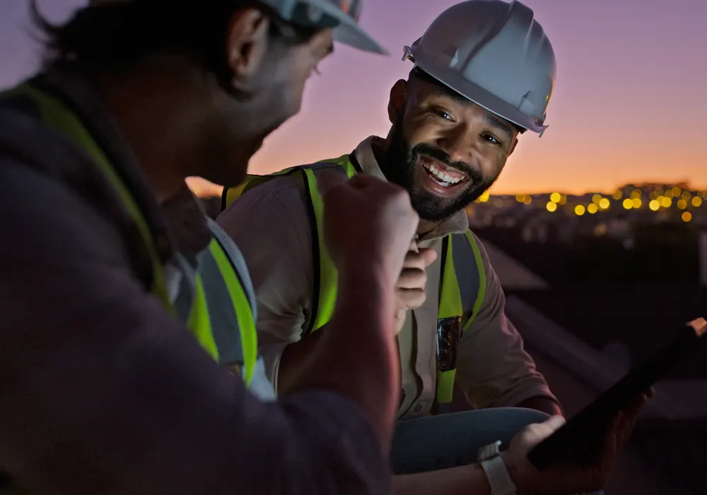 Two engineers in the field at night celebrating success